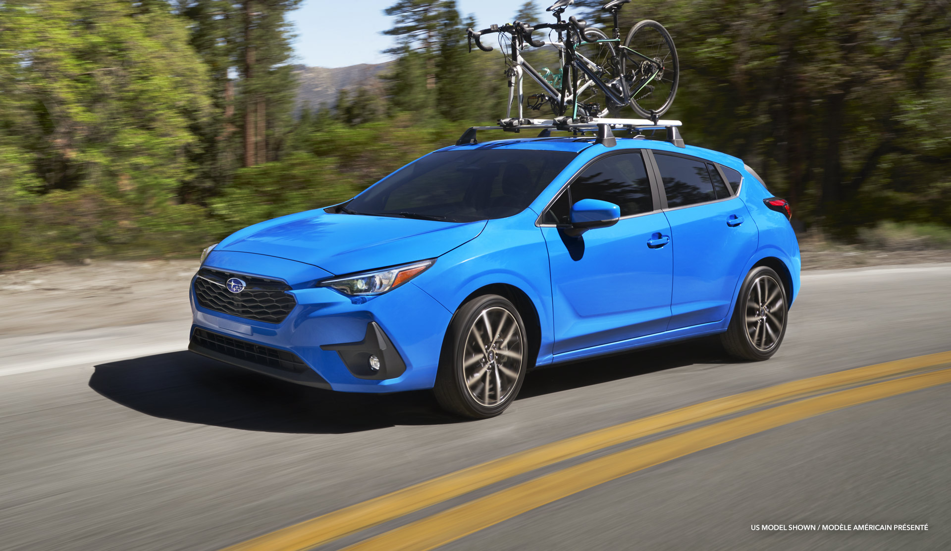 2024 Impreza with bicycles on roof, driving on the road.